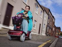 Image of a lady using a mobility scooter